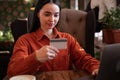 Girl with long hair holding credit card and using laptop making payment online sitting in cafe. Online shopping, e Royalty Free Stock Photo