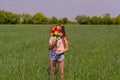 A girl with long hair holds in her hands a colored windmill toy on a green field on a sunny day Royalty Free Stock Photo