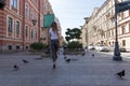 Girl with long hair in jeans and t-shirt walking down the street