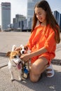 girl with long hair and orange comfy clothes with two small adorable dogs Jack Russell terriers