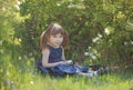 A girl with long hair sits in the spring garden Royalty Free Stock Photo