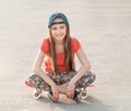 Girl with long hair sitting on skating board Royalty Free Stock Photo