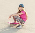 Girl with long hair sitting on skating board Royalty Free Stock Photo