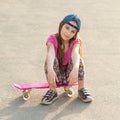 Girl with long hair sitting on skating board Royalty Free Stock Photo