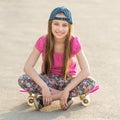 Girl with long hair sitting on skating board Royalty Free Stock Photo