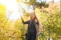 A girl with long hair swinging on a swing in an autumn park. Royalty Free Stock Photo