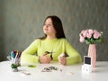 Girl with long hair and a yellow sweater Weaves Beaded jewelry Royalty Free Stock Photo