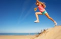 Girl in long jump from sand dune on the sea beach Royalty Free Stock Photo