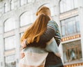 Girl with long thick dark hair holding hands redhead boy in blue t-shirt on bridge, teen love at evening. Boy looks tenderly at