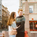 Girl with long thick dark hear embracing redhead boy in blue t-shirt on bridge, young couple. Concept of teenage love. they look Royalty Free Stock Photo
