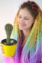 A girl with a long wavy hair painted in rainbow colors and cactus . Tunic hair kanekalon Royalty Free Stock Photo