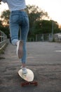 Girl with longboard wearing sneakers shoes in urban style