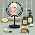 Girl look at the mirrow and skincare. Cosmetic bottles elements. Bath room and beauty table.