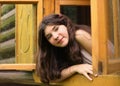 girl look out of wooden window in block country house Royalty Free Stock Photo