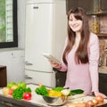 Girl look at the tablet.Young Woman Cooking in the kitchen at home. Healthy Food.