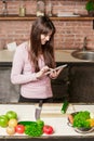 Girl look at the tablet.Young Woman Cooking in the kitchen at home. Healthy Food.