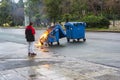 Girl looking a burnt and melted trash bin from fire in the city of Athens after a demonstration event