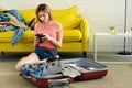 girl looking at camera while packing suitcase Royalty Free Stock Photo
