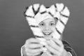 Girl looking through crossed candy canes close up defocused. Christmas decorating ideas. Child Santa Claus costume hold