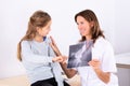 Girl Looking At Doctor Holding Bone X-ray