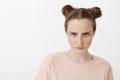 Girl looking at enemy, feeling scorn and anger, looking from under forehead at camera and frowning, standing serious and Royalty Free Stock Photo