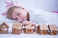 The girl is looking forward to Christmas. The child is waiting for Santa Claus. The child plays with wooden garlands Royalty Free Stock Photo