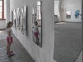 A girl looking at her image in the distorted mirror in the hall of mirrors Royalty Free Stock Photo