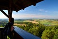 Girl looking from lookout tower to green czech countryside