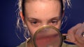 Girl looking through a magnifying glass on a Zit