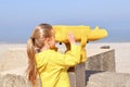 A girl looking at the ocean through a binoscope Royalty Free Stock Photo