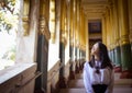 Girl looking out window at Shwedagon Pagoda, Yangon