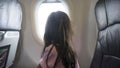 Girl looking outside from airplane window