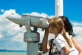 Girl looking through pay-to-use telescope Royalty Free Stock Photo