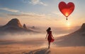 girl looking at red hot air balloons. Balloons in shape of heart flying in the sunset sky. Wedding, Valentine, love concept. Royalty Free Stock Photo