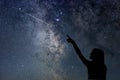 Girl looking at the stars. Girl pointing a shooting star. Royalty Free Stock Photo