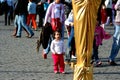 Little girl looking at a street entertainer. Royalty Free Stock Photo