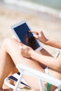 Girl looking at tablet pc on the beach Royalty Free Stock Photo