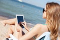 Girl looking at tablet pc on the beach Royalty Free Stock Photo