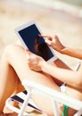 Girl looking at tablet pc on the beach Royalty Free Stock Photo