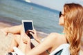 Girl looking at tablet pc on the beach Royalty Free Stock Photo