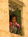 Girl looking to the street behind window, Mahwit. Yemen