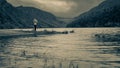 Girl is looking toward mountain and lake in the Wicklow Mountains, Glendalough Upper lake covered with mist and fog in upper part,