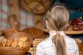 The girl is looking at wood products on the market. View from th Royalty Free Stock Photo