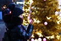 girl looks at beautiful artificial Christmas tree in evening city