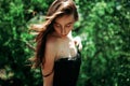 The girl looks cute at the ground in a black dress in the forest Royalty Free Stock Photo