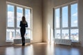 A girl looks into large stained glass windows in an empty apartment