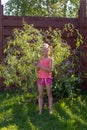 Girl looks at the leaves on young willow