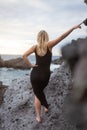 Girl looks at the ocean dressed in a long black dress, feminine curves Royalty Free Stock Photo