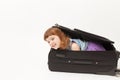 The girl looks out of the suitcase and laughs Royalty Free Stock Photo