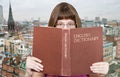 Girl looks over English Dictionary and skyline